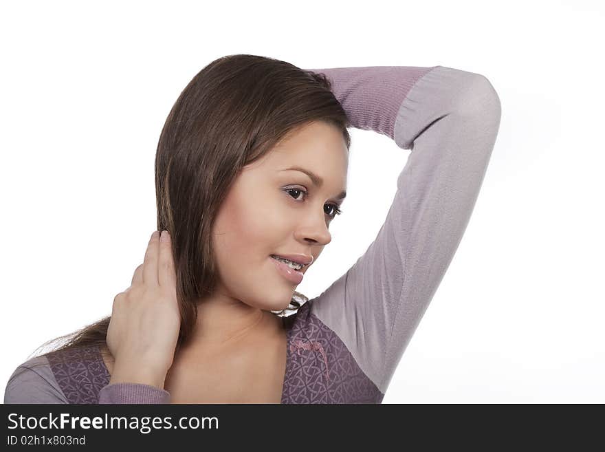 Girl with dark hair uses brackets with happy facial expression and looking down standing isolated over white background