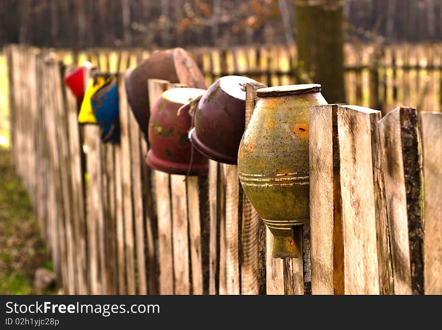 Old wooden boundary fence with nails on sunny day