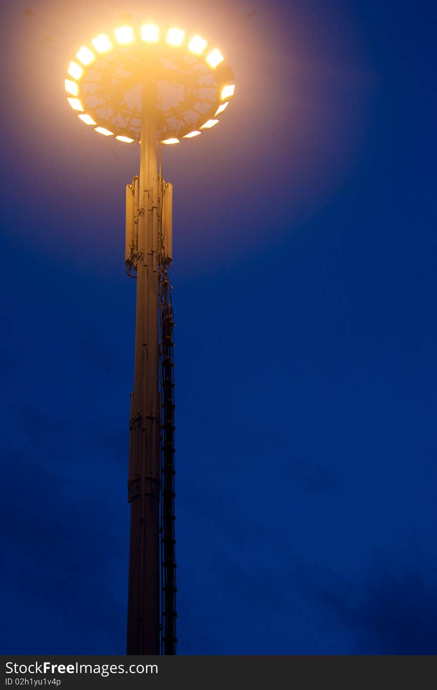 Big light pole against the blue sky at night