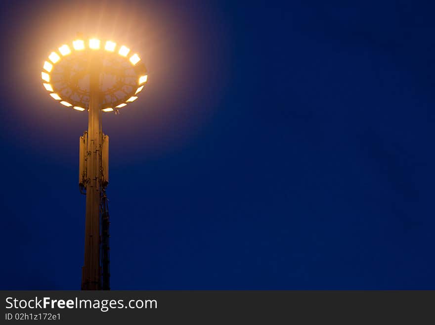 Big light pole against the blue sky at night