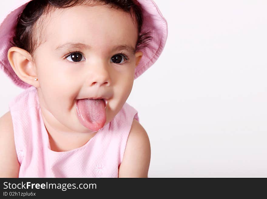 Baby with pink dress, gesturing with his mouth. Baby with pink dress, gesturing with his mouth