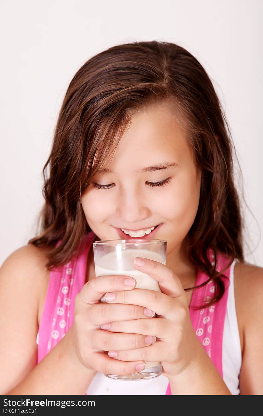 Happy girl drinking milk over white background. ten years old