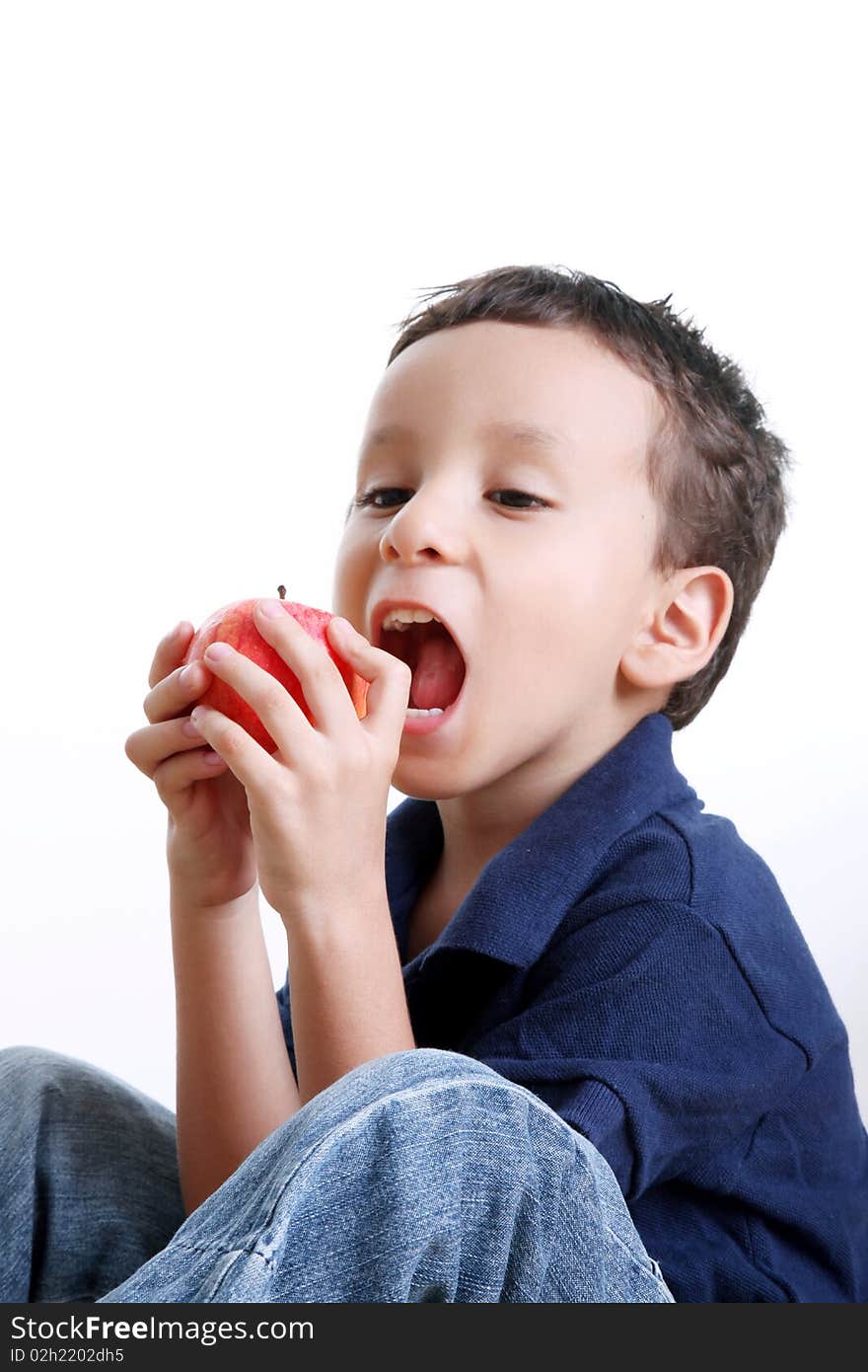 Child eating apple over white background. Healthy food