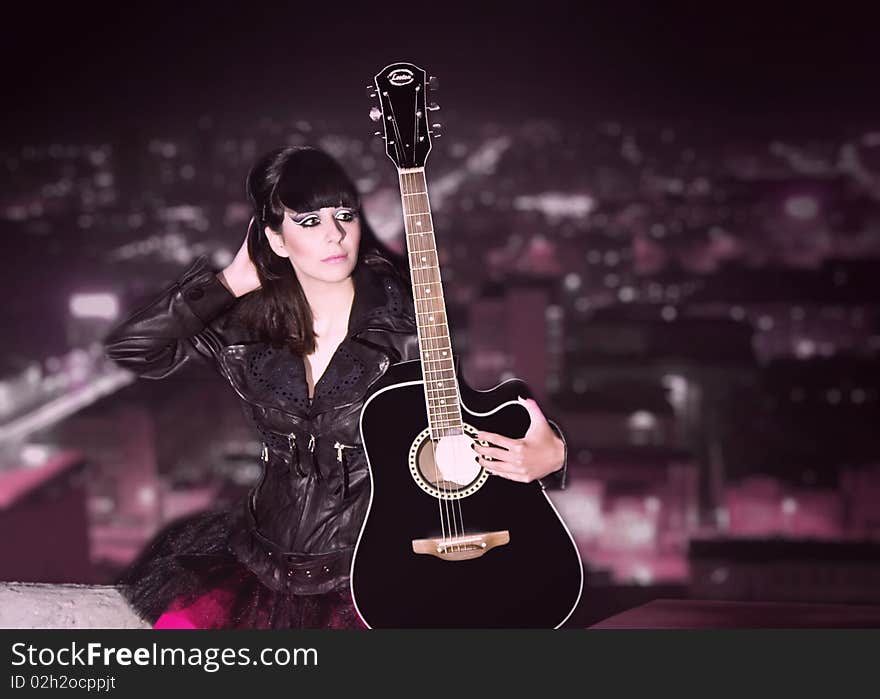 The young girl with a guitar on a roof of a high-rise building. The young girl with a guitar on a roof of a high-rise building