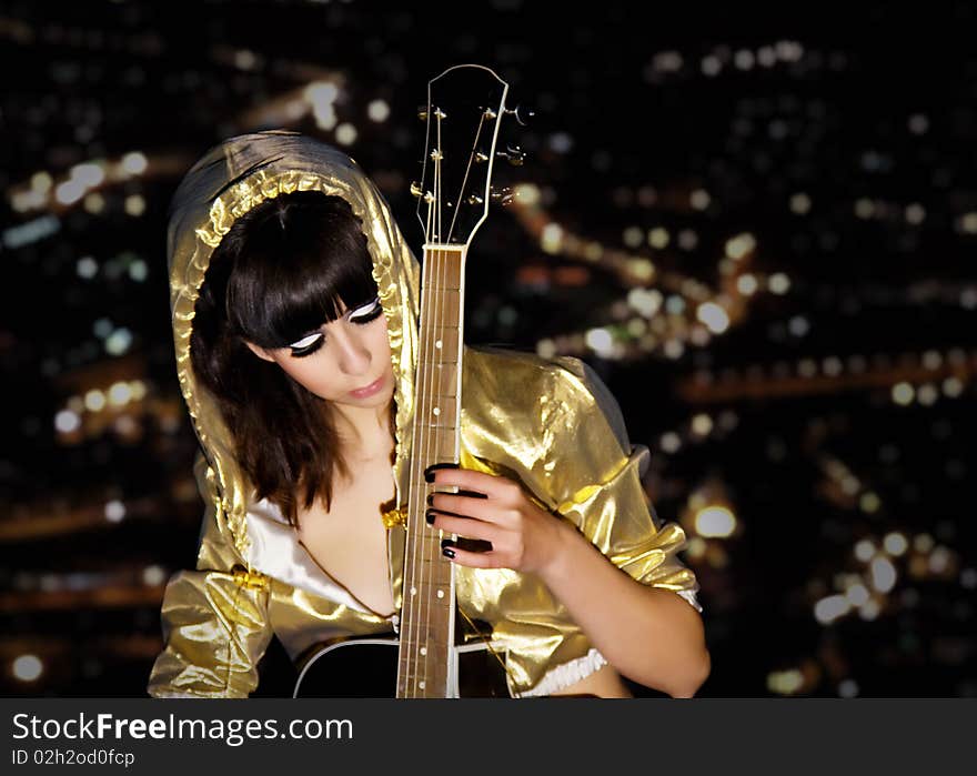 The young girl with a guitar on a roof of a high-rise building. The young girl with a guitar on a roof of a high-rise building