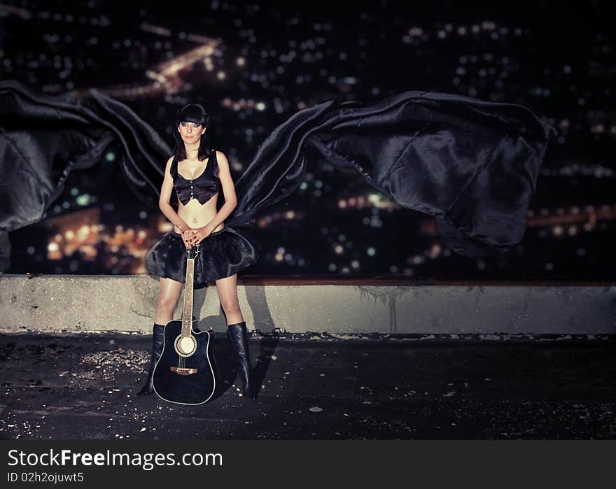 young girl with a guitar on a roof of a high-rise building. young girl with a guitar on a roof of a high-rise building