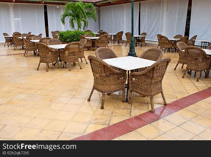 Brown wooden chairs an tables on patio in the morning