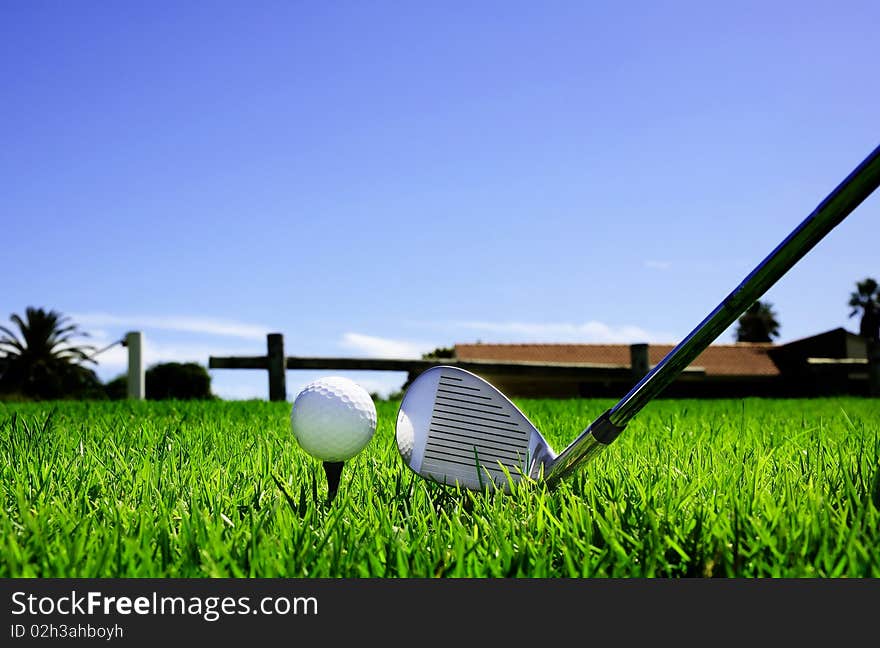 Ball and golf clubs on the bright green grass - as a symbol of success