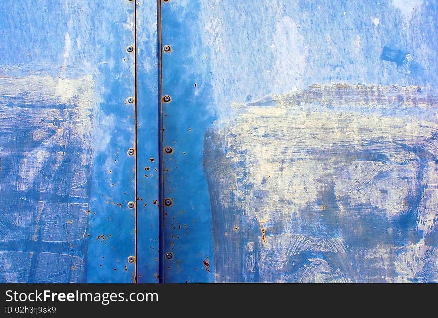 Detail of the old iron door painted in blue.