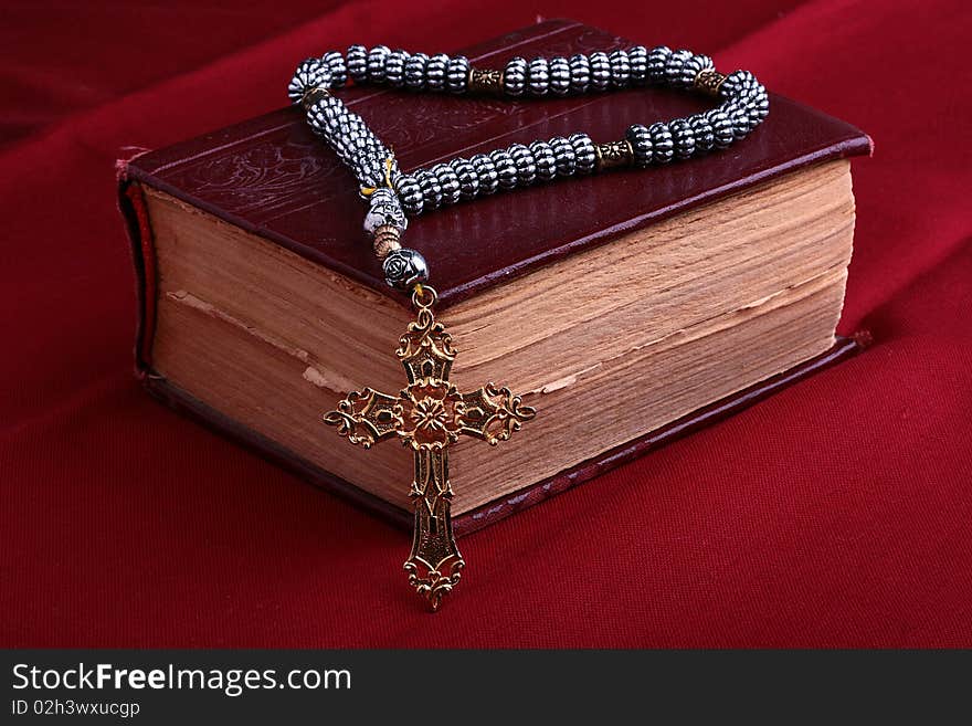 The old bible and cross on a red background.