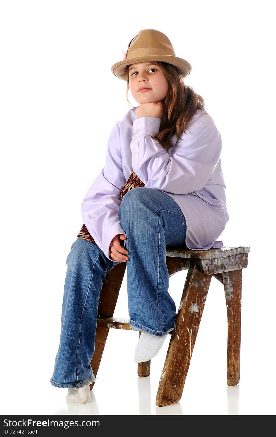 A serious preteen girl sitting on a battered step-stool wearing grandpa's clothes. Isolated on white. A serious preteen girl sitting on a battered step-stool wearing grandpa's clothes. Isolated on white.