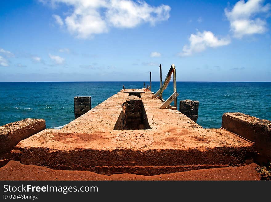 An abandoned concrete pier structure in Hawaii, overlooking the ocean. An abandoned concrete pier structure in Hawaii, overlooking the ocean.