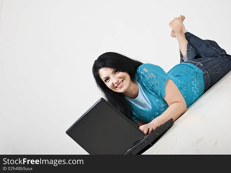 Happy beautiful woman lying down on wooden floor and using a laptop,copy space for text message,see more in People on couch or wooden floor. Happy beautiful woman lying down on wooden floor and using a laptop,copy space for text message,see more in People on couch or wooden floor