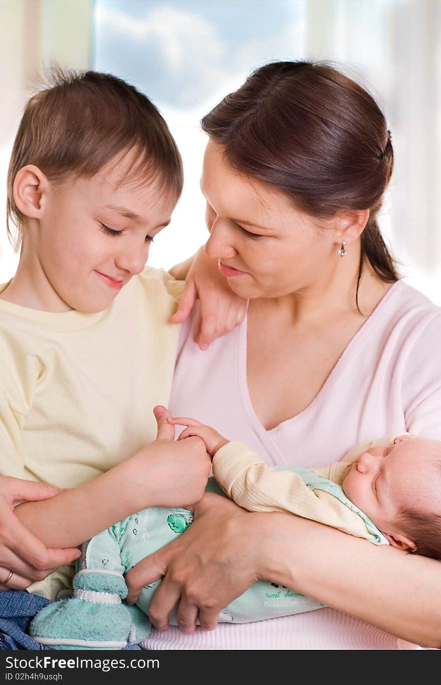 Young mother sits with her two children. Young mother sits with her two children