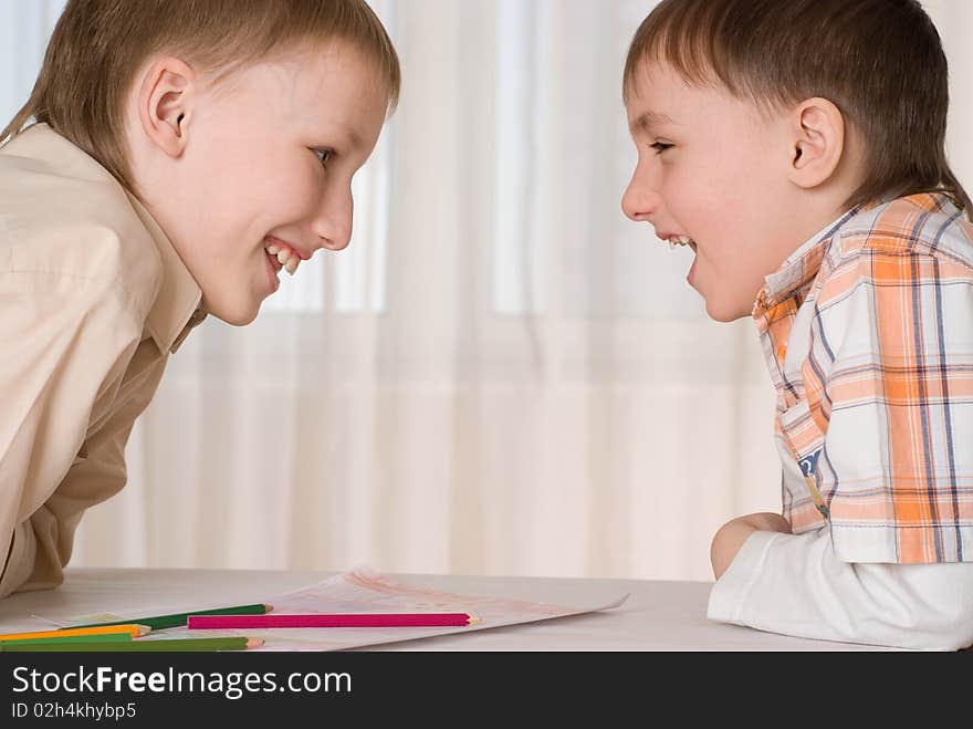 Two brothers sitting at the table and a smile