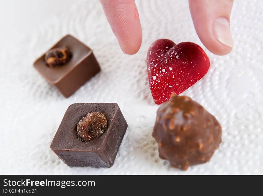 Chocolate candies with nuts on white surface. Chocolate candies with nuts on white surface