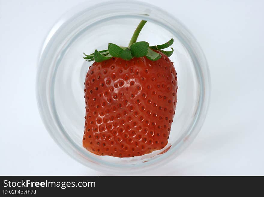 A wine glass viewed from above with a strange strawberry inside. A wine glass viewed from above with a strange strawberry inside