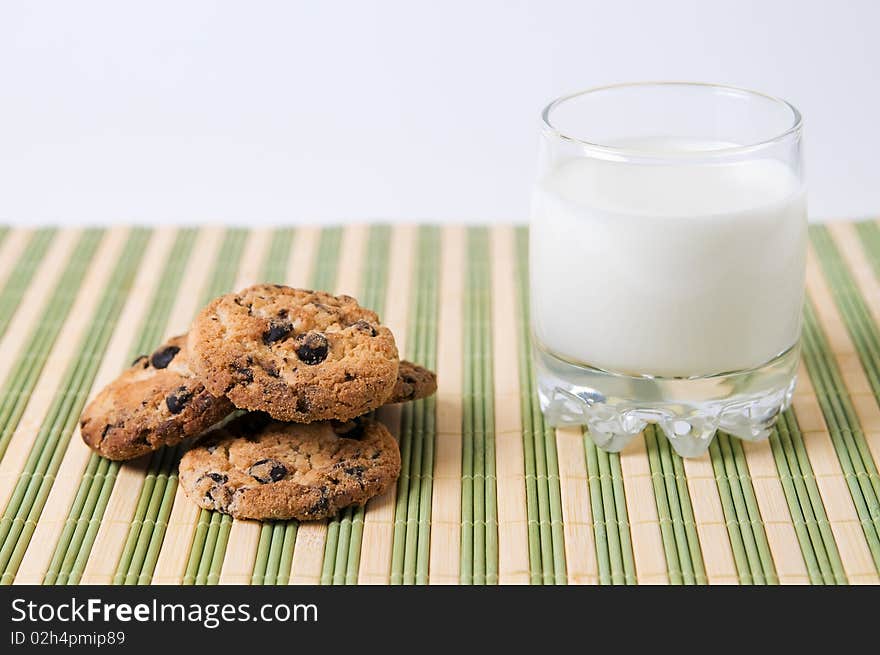 Glass of milk and chocolate cookies on stripe surface. Glass of milk and chocolate cookies on stripe surface