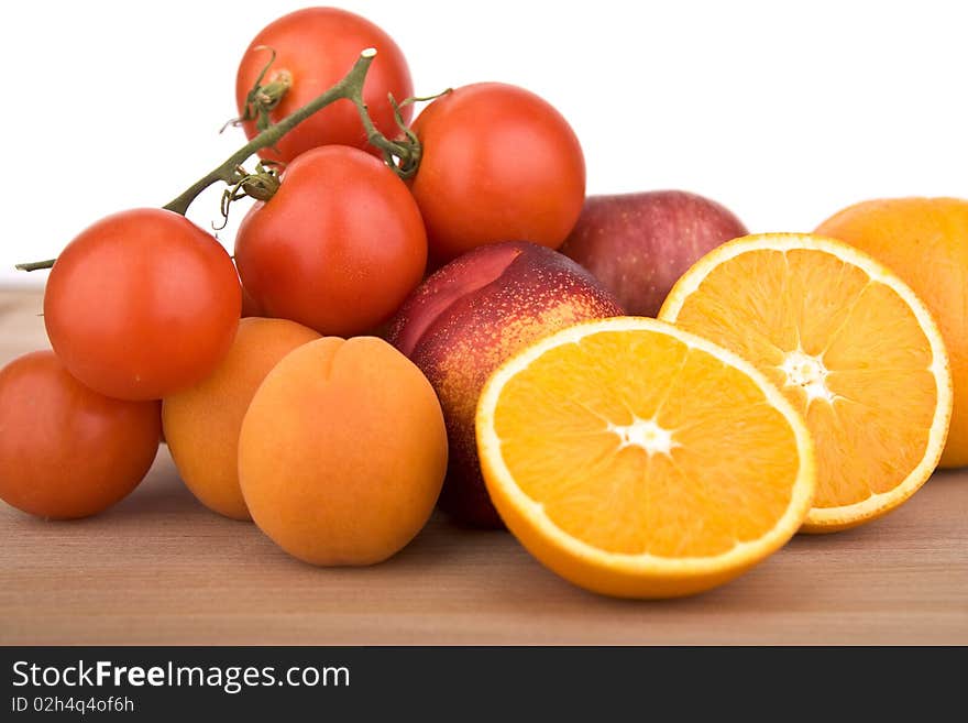 Collection of fruits like orange, tomatoes, peach and plums