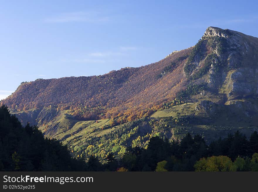 Autumnal forest and rocky peak in the Pyrenees, Spain