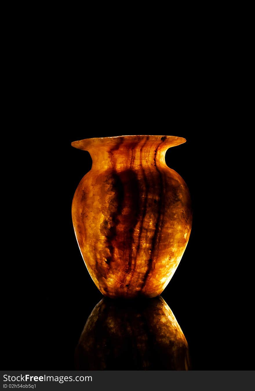 Alabaster vase in dark background with light reflect