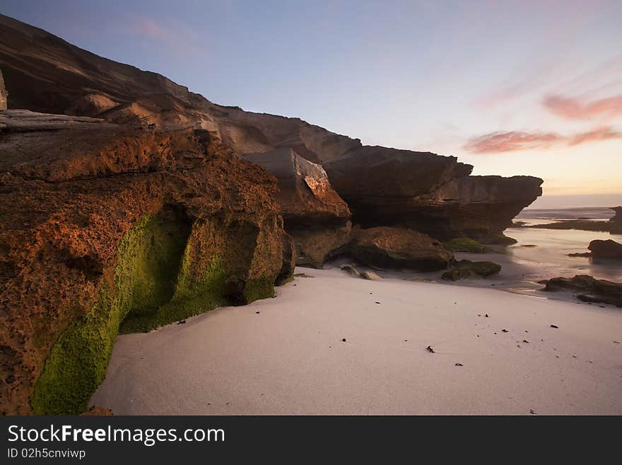 Image of a rock with moss on at a beach in South Africa. Image of a rock with moss on at a beach in South Africa