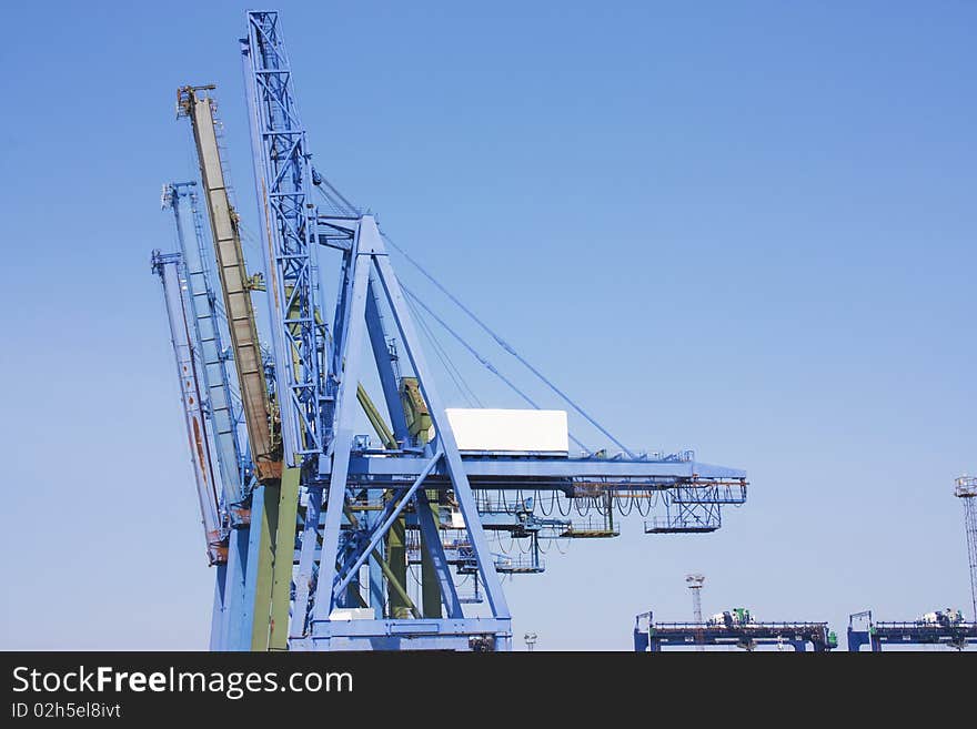 Big blue cranes at the dcosk for laoding container ships. Big blue cranes at the dcosk for laoding container ships