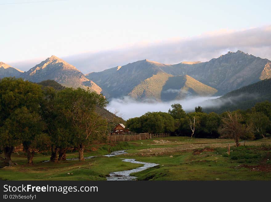 Mountains, green grass and blue stream landscape