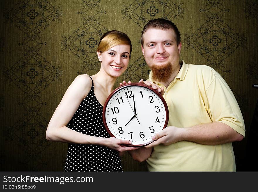 An image of a man and a woman with a clock. An image of a man and a woman with a clock