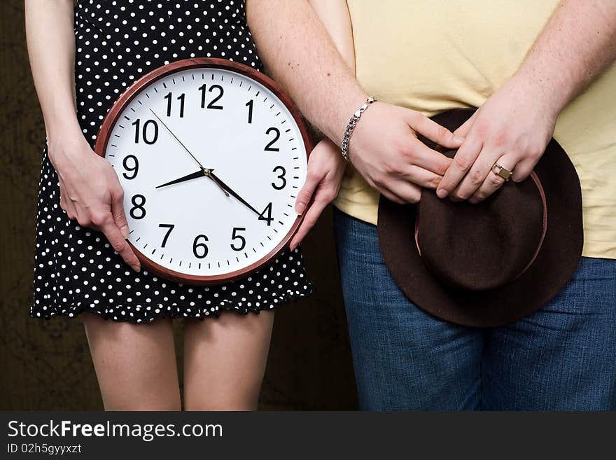 An image of man and woman with hat and clock. An image of man and woman with hat and clock