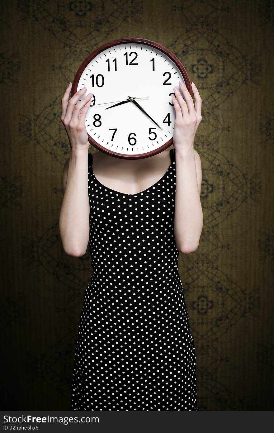 An image of a girl holding a big white clock. An image of a girl holding a big white clock