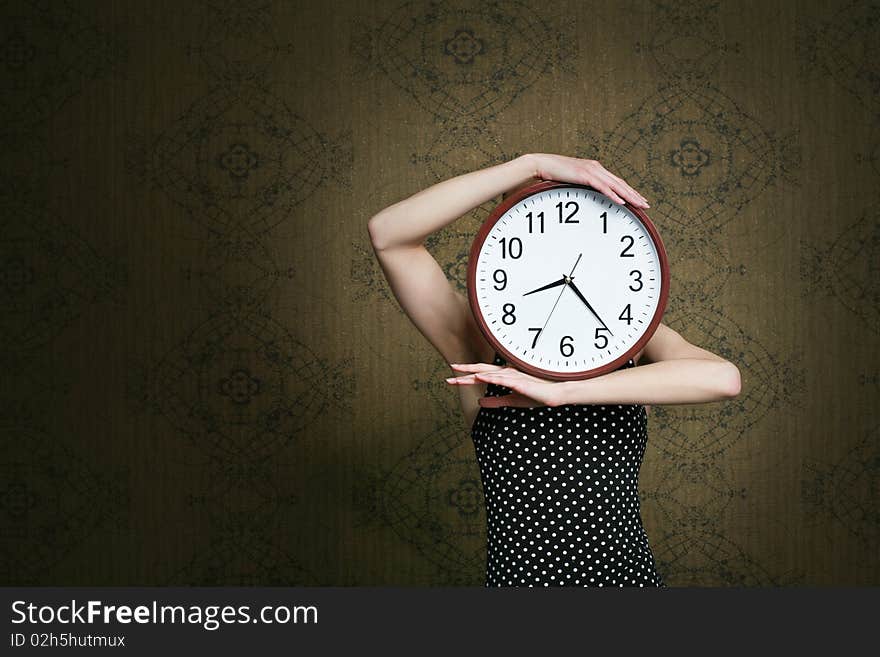 An image of a girl holding a big white clock