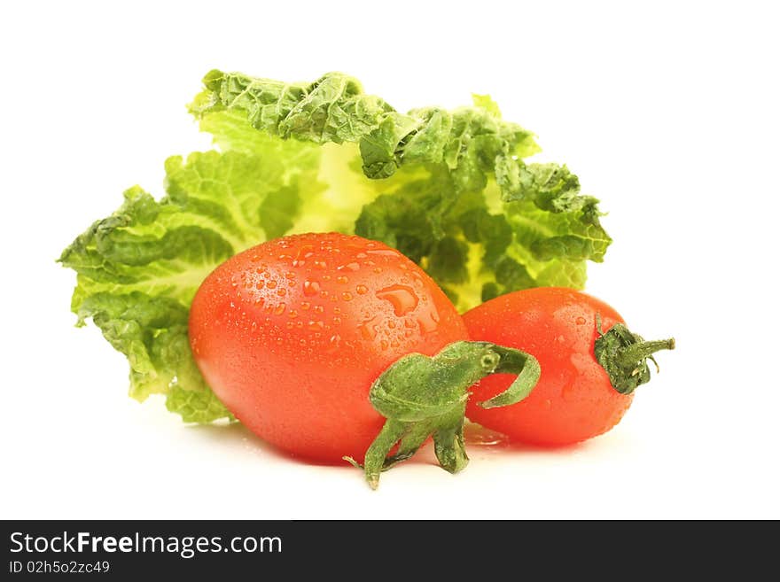 Tomato with drops of water and leaf of cabbage isolated on white background. Tomato with drops of water and leaf of cabbage isolated on white background