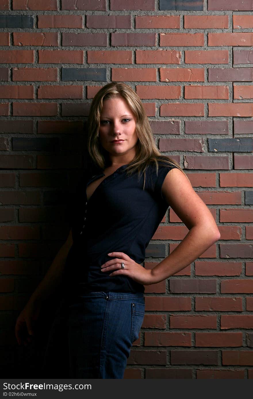 Pretty Woman In Black Shirt Against Brick Wall