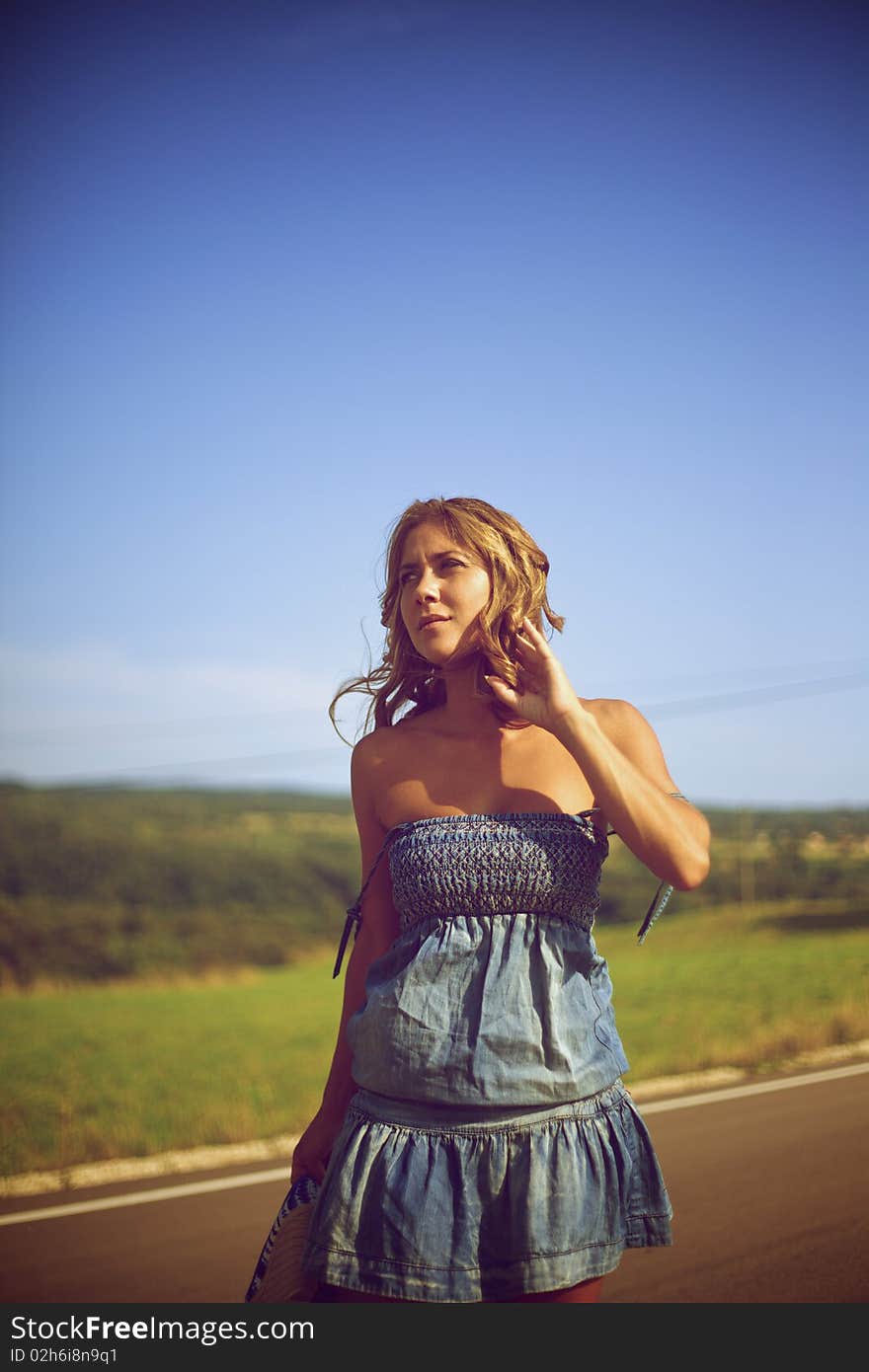 Beautiful fashion female model looking away and sitting on the road. Beautiful fashion female model looking away and sitting on the road