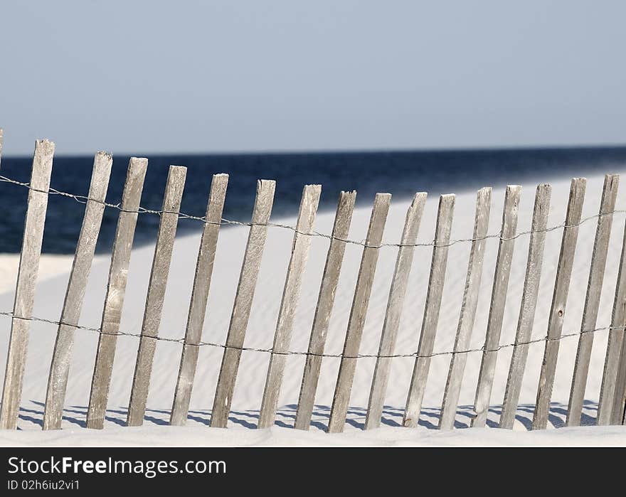 A fence on a white sandy beach in Orange Beach AL. A fence on a white sandy beach in Orange Beach AL.