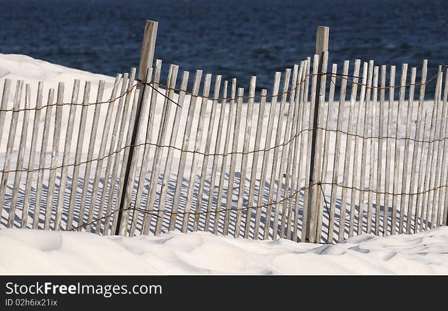 A fence on a white sandy beach in Orange Beach AL. A fence on a white sandy beach in Orange Beach AL.