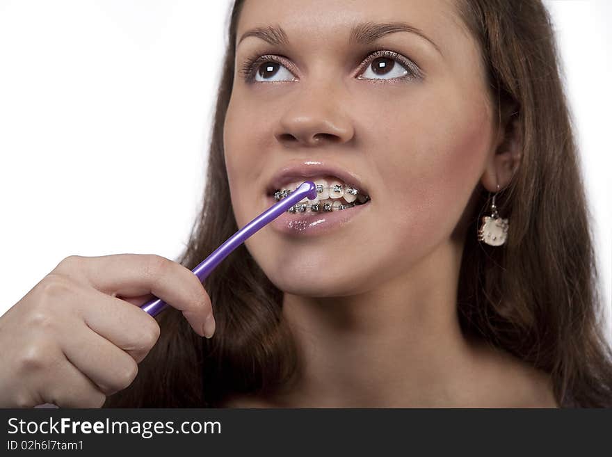 Teeth and bracket system cleaning procedure using round toothbrush standing isolated over white background. Teeth and bracket system cleaning procedure using round toothbrush standing isolated over white background