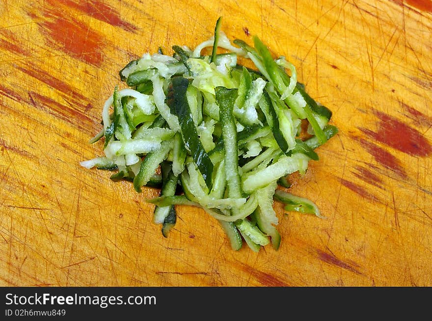 Green small cucumber  grated on wooden board