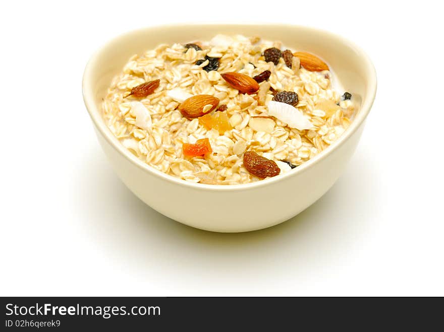 Bowl of healthy fruit and nut muesli on white. Bowl of healthy fruit and nut muesli on white