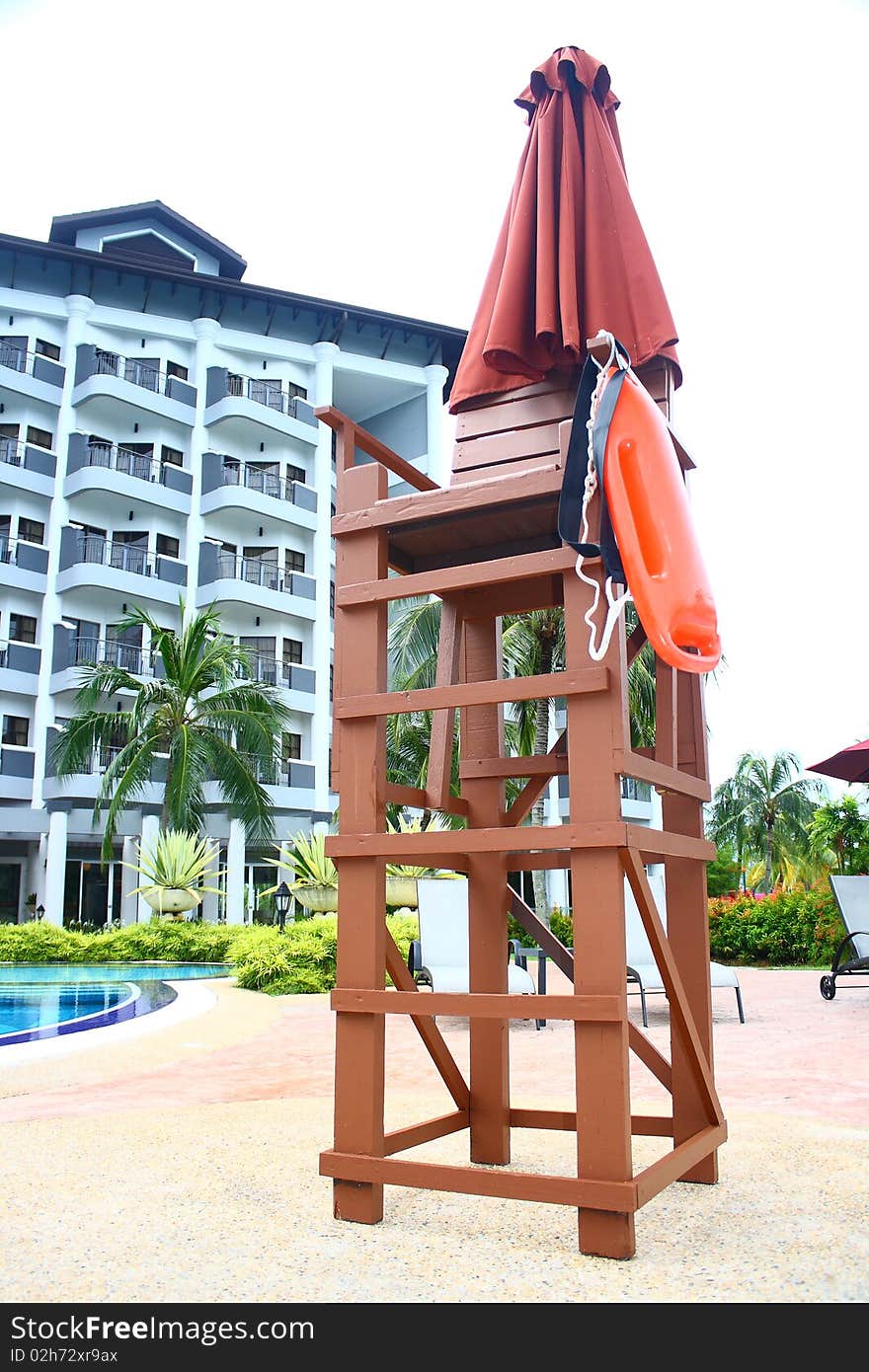 An image showing a lifeguard chair at a poolside of a luxury hotel. An image showing a lifeguard chair at a poolside of a luxury hotel