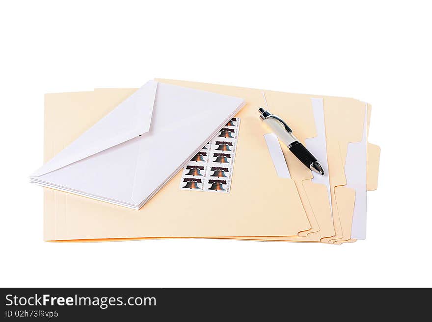 Office table with folders in which envelopes and documents and pen are enclosed.