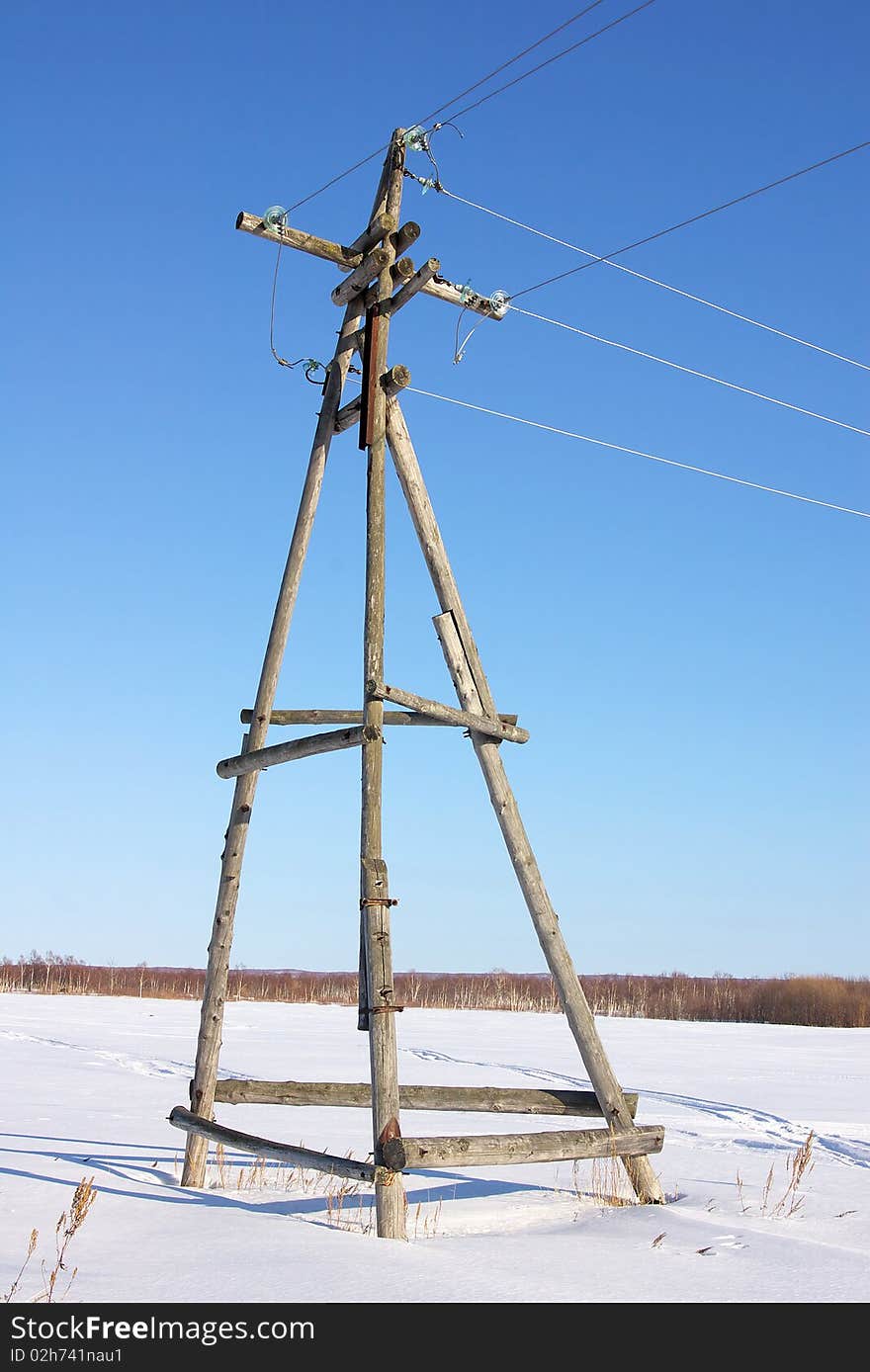 Wooden electric base, decrepit from old age, standing in the open field. Wooden electric base, decrepit from old age, standing in the open field