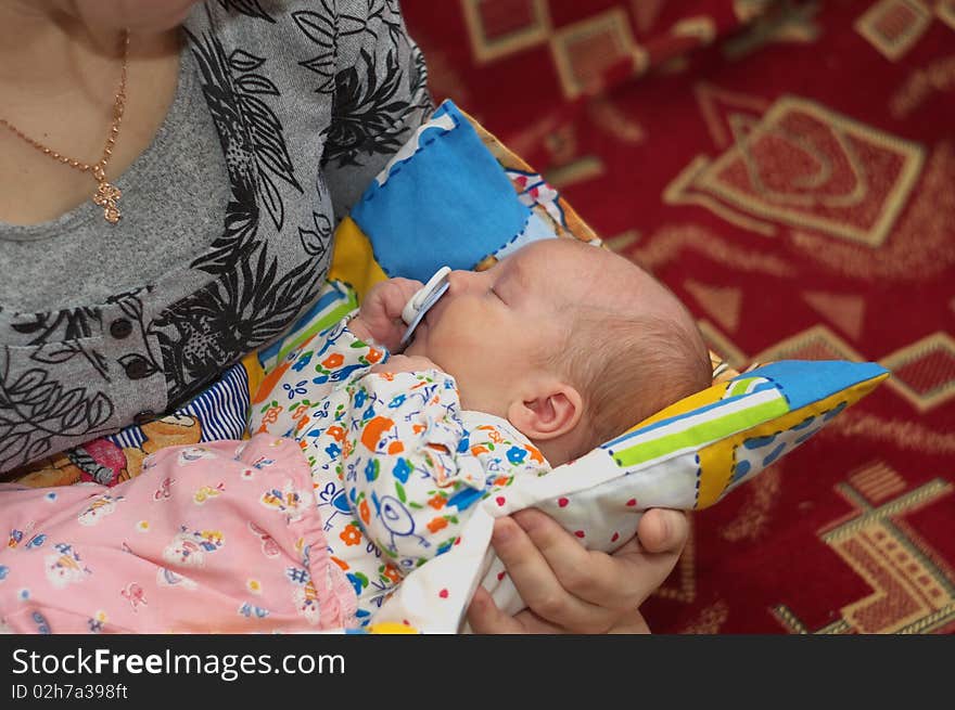 Photo of the sleeping baby on mother hands