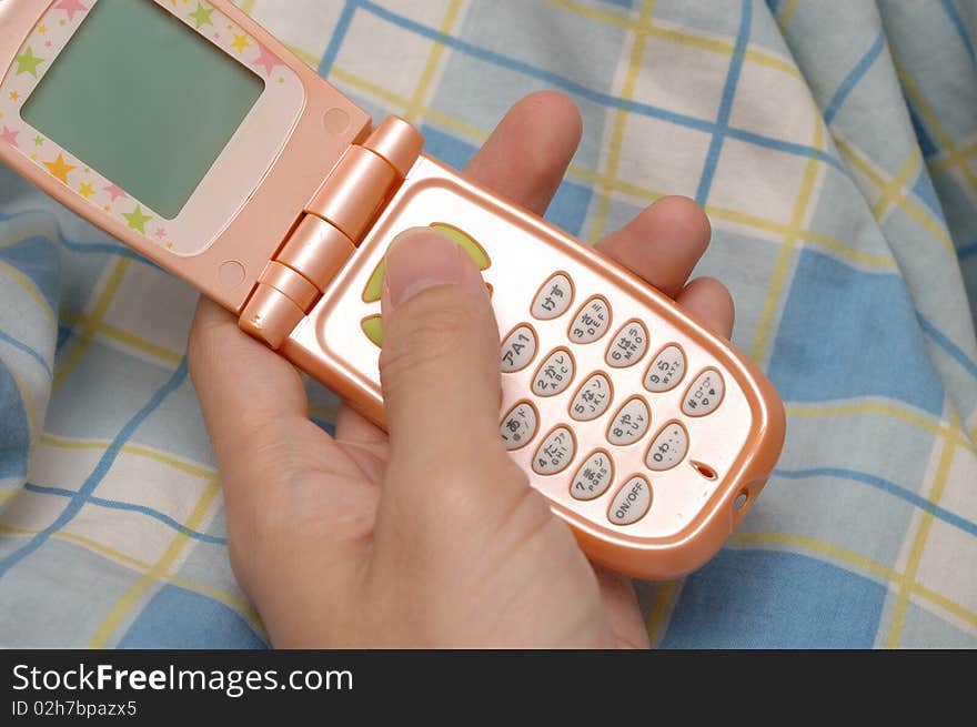 A feminine mobile phone in the hand, the keyboard with Japanese symbol.