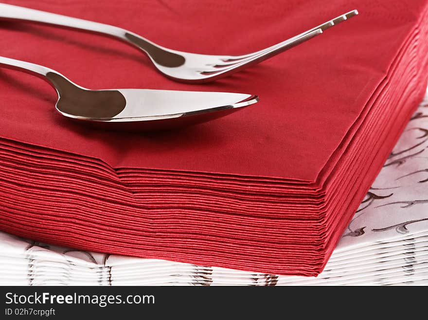 Silvery fork and spoon on red napkin. Silvery fork and spoon on red napkin