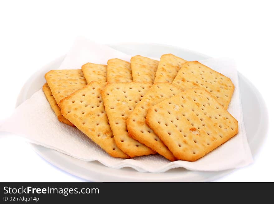 Crackers on plate isolated on white background.