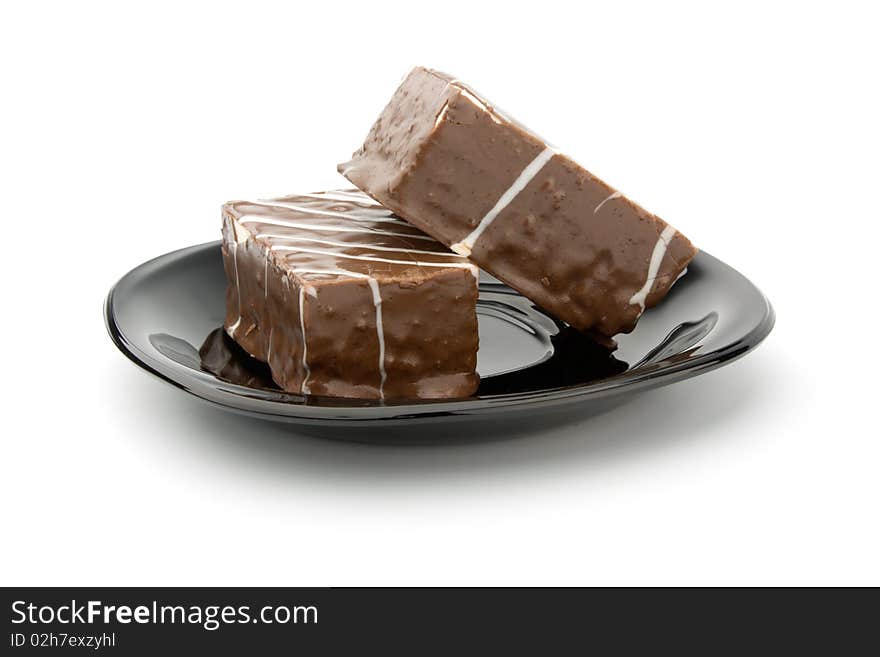 Two cookie in chocolate on black plate isolated on white