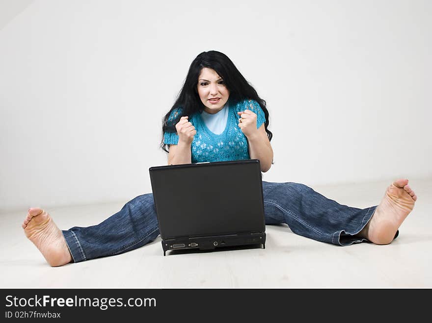 Stressed woman expecting something on her laptop or hoping to not crash and sitting on floor with all body strained.Check also Facial expressions and gesture. Stressed woman expecting something on her laptop or hoping to not crash and sitting on floor with all body strained.Check also Facial expressions and gesture