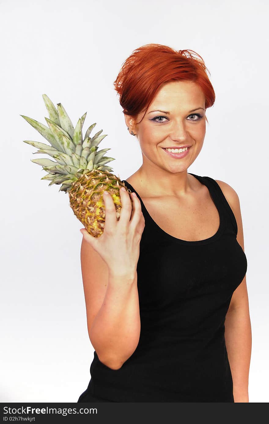 Smiling girl with pineapple in the hand on the white background